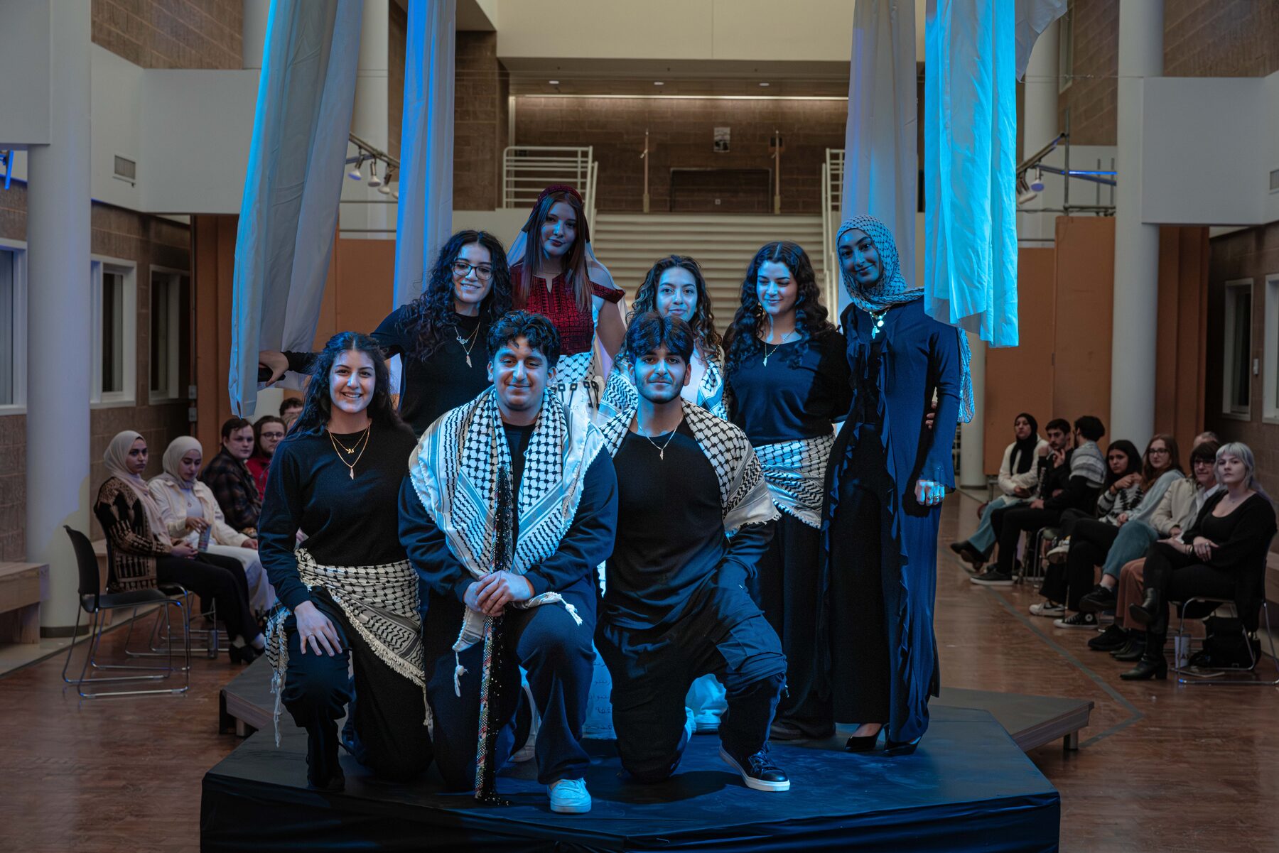 Aswat Al Ard troupe posed on stage after performing at the NOMAS fashion show